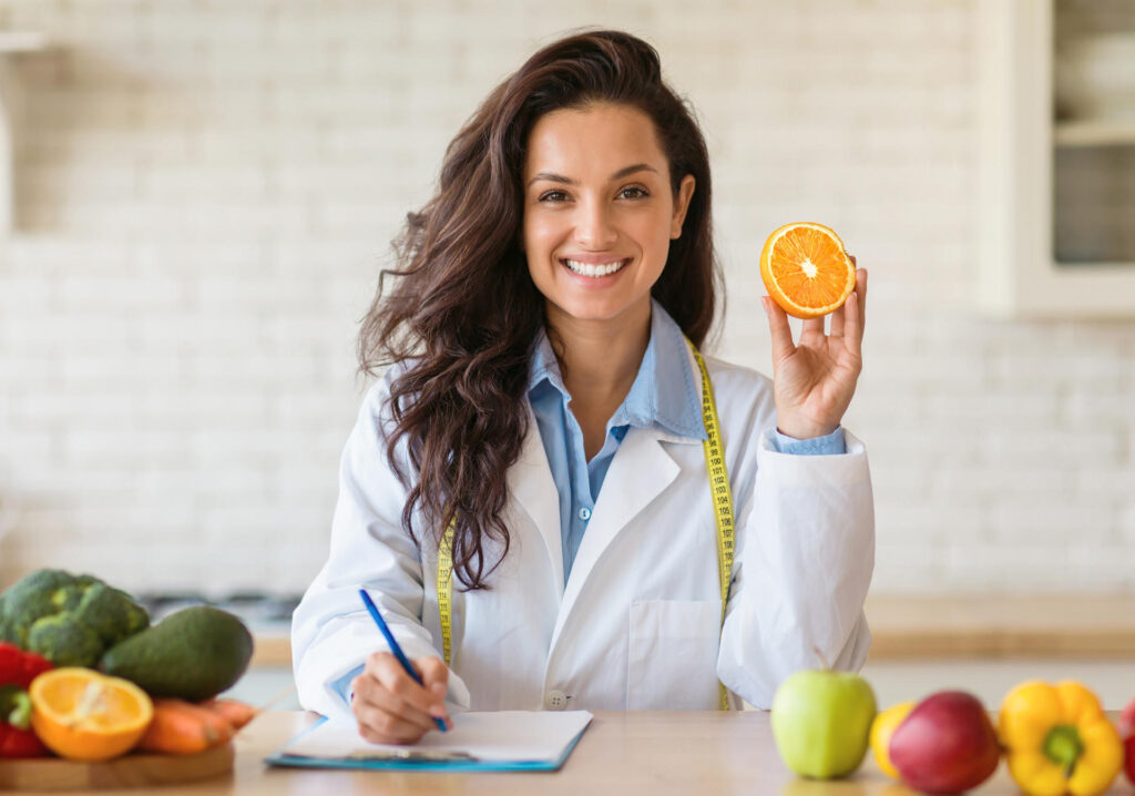 Consejera de nutrición sosteniendo una naranja