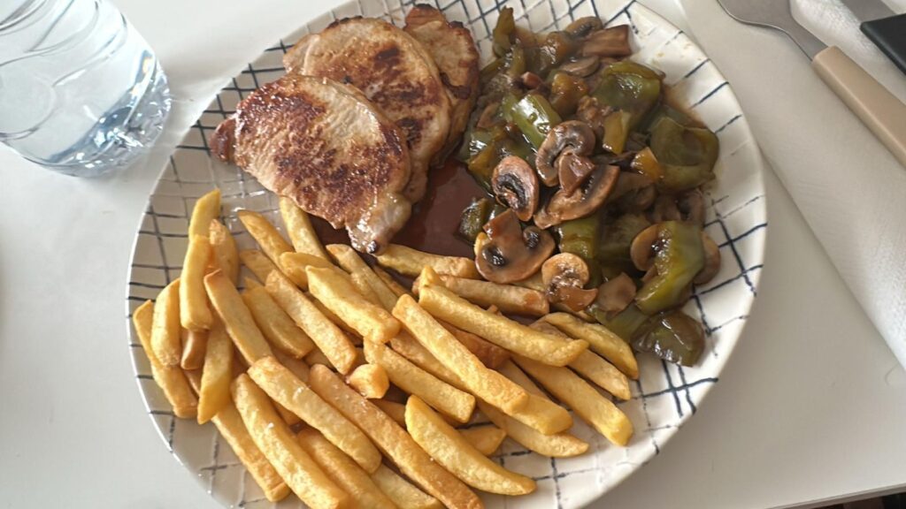 Plato de comida real con carne, champiñones y patatas fritas dentro de un plan para perder grasa